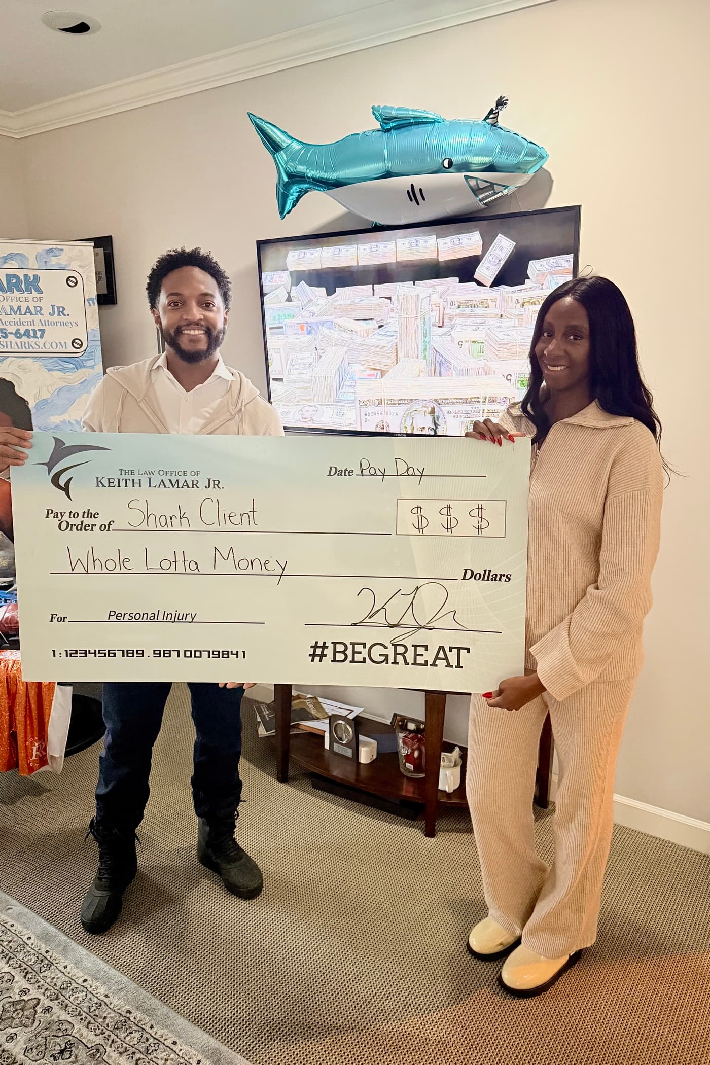 Keith Lamar Jr. and a client holding a novelty check