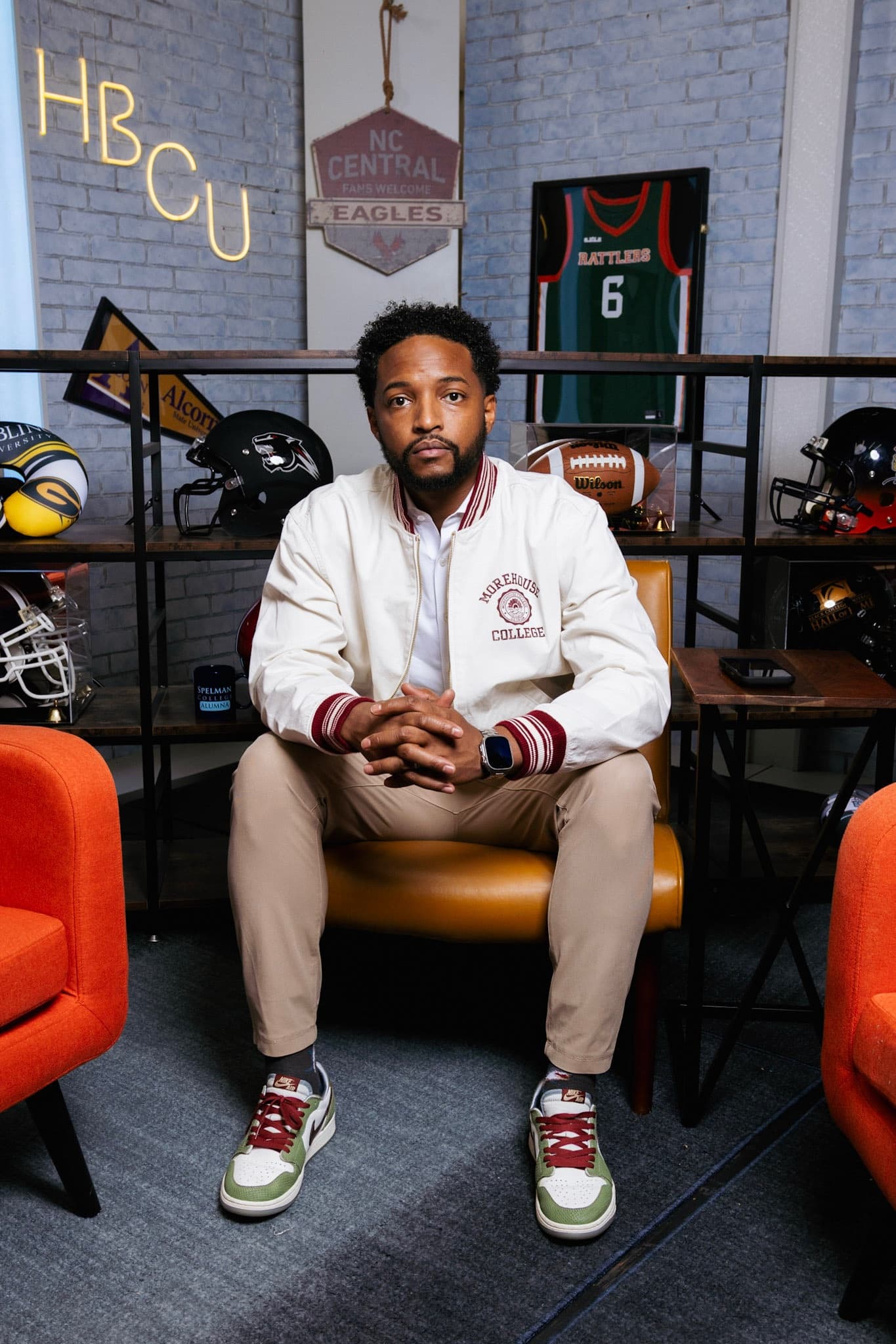 Keith Lamar Jr. seated in front of a display of HBCU memorabilia, wearing a Morehouse College jacket